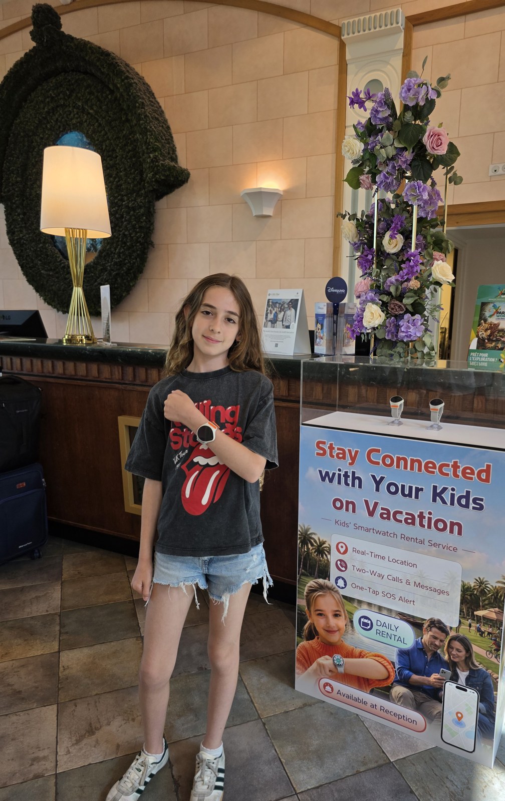 A young hotel guest checks her rented KidiLink watch